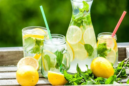 fresh homemade lemonade in pincher and jar of green bluered background