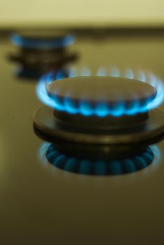 abstract gas burner with blue flame on dark background