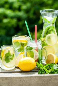 fresh homemade lemonade in pincher and jar of green bluered background