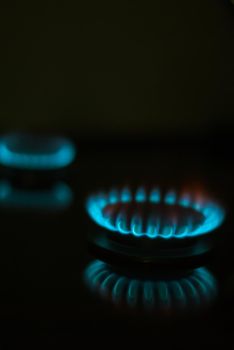 abstract gas burner with blue flame on dark background