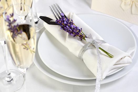 Indulge in a dose of romantic French countryside inspiration with fresh lavender, Lavender Champagne, a folded napkin with cutlery. Detail of the wedding dinner. Wedding theme ideas.