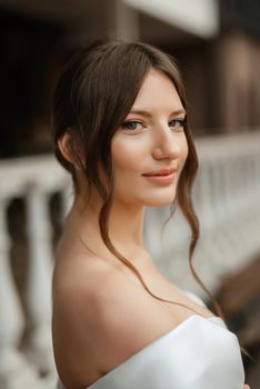 portrait of a young bride girl in a short white dress on a rainy day