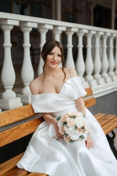 portrait of a young bride girl in a short white dress on a rainy day