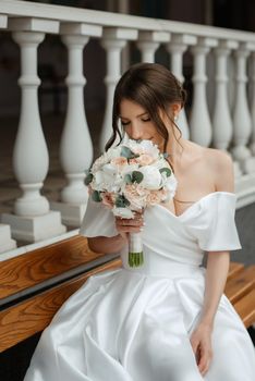 portrait of a young bride girl in a short white dress on a rainy day