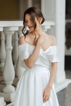 portrait of a young bride girl in a short white dress on a rainy day