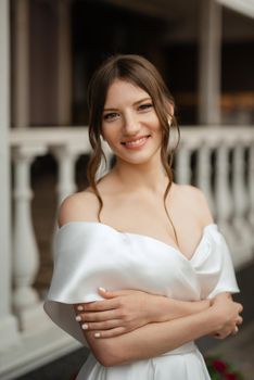 portrait of a young bride girl in a short white dress on a rainy day