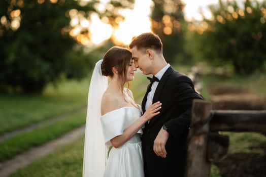 young couple the groom in a black suit and the bride in a white short dress on a walk in the village