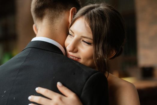 young couple bride and groom in a white short dress walking in the rain