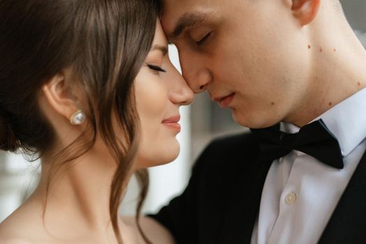 young couple bride and groom in a white short dress walking in the rain