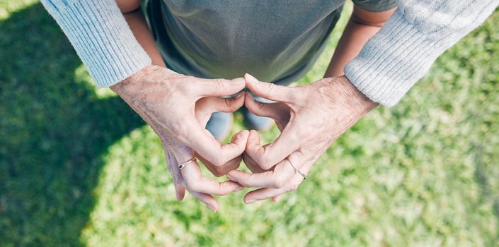 Nurturing with love. an unrecognizable little boy and his grandmother holding their hands together in a heart shape outside