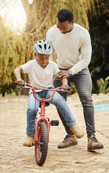 Taste of freedom. an adorable boy learning to ride a bicycle with his father outdoors