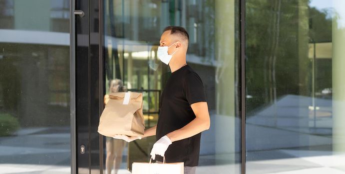 delivery guy in protective mask near the customer house, outdoors