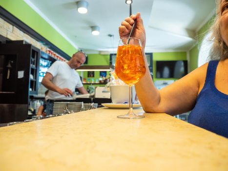 caucasian senior woman having a cocktail at the counter