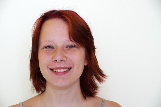 Portrait of smiling teenage girl on white background, copy space