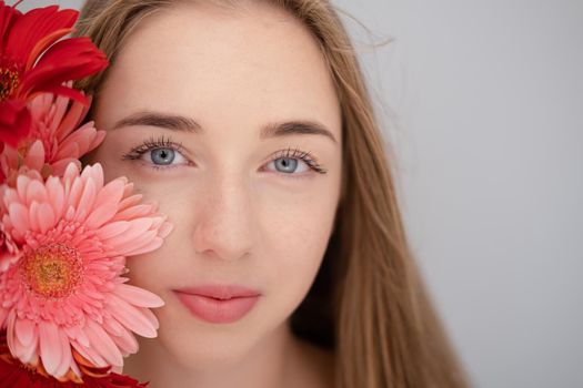 Portrait of pretty young woman with pink and red chrysanthemum flowers.