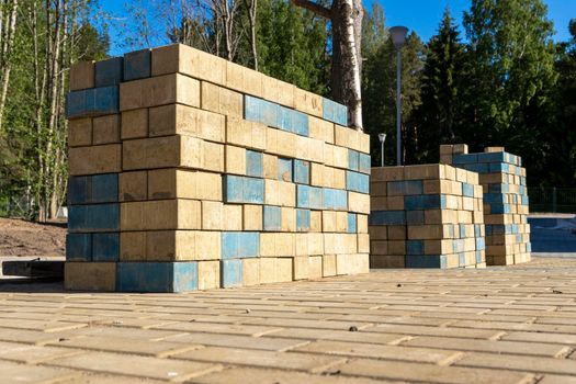 stacks of new colored paving slabs for paving paths stacked on a construction site in a city park. improvement of the city, paving of sites