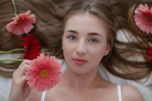 Portrait of pretty young woman with pink and red chrysanthemum flowers.