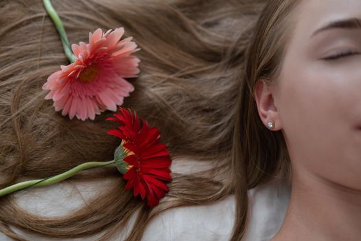 Portrait of pretty young woman with pink and red chrysanthemum flowers.