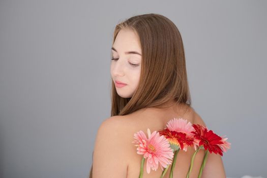 Portrait of pretty young woman with pink and red chrysanthemum flowers.