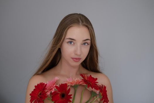 Portrait of pretty young woman with pink and red chrysanthemum flowers.