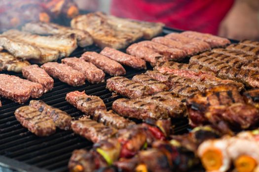 Grilling tasty food on barbecue. Steak, sausages on grill at food festival