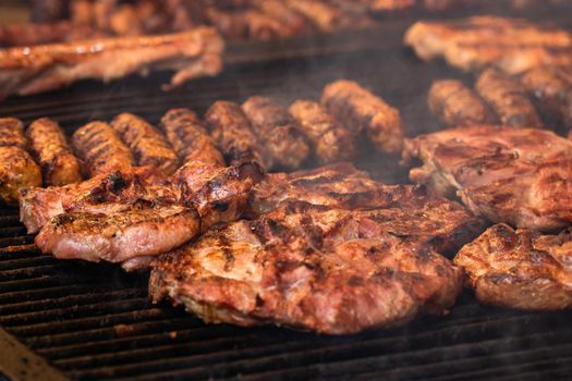 Grilling tasty food on barbecue. Steak, sausages on grill at food festival