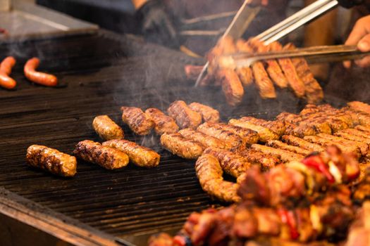 Grilling tasty food on barbecue. Steak, sausages on grill at food festival