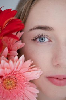 Portrait of pretty young woman with pink and red chrysanthemum flowers.