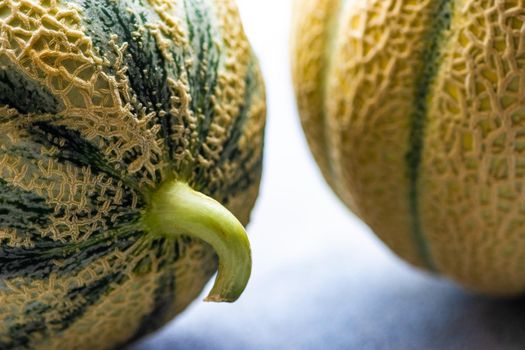 Textured fresh and ripe cantaloupe melons on concrete background