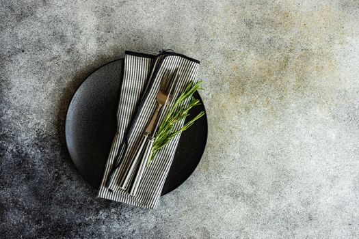 Cutlery set with textile napkin and silverware on concrete table