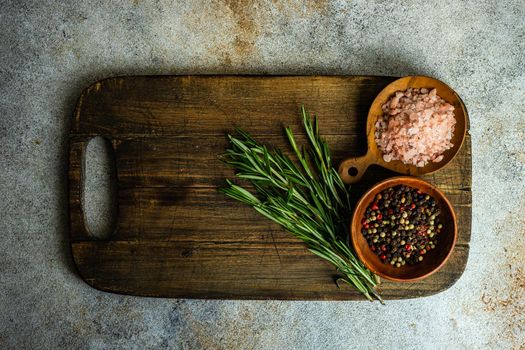 Cooking concept with spices and rosemary herb on concrete background