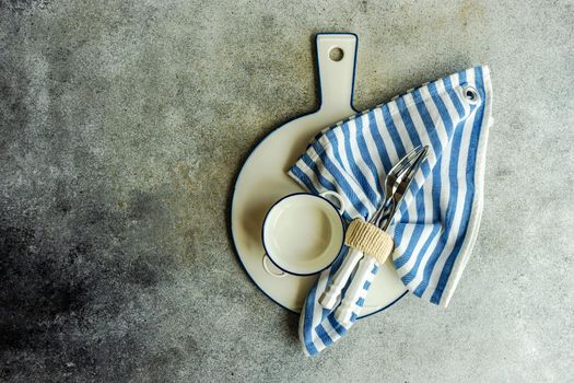 Cutlery set with textile napkin and silverware on concrete table