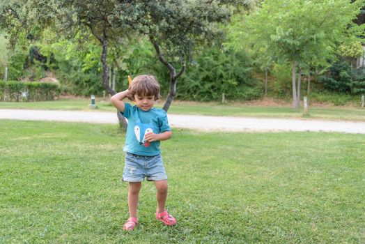 Happy kid playing with toy airplane against summer sky background at sunset