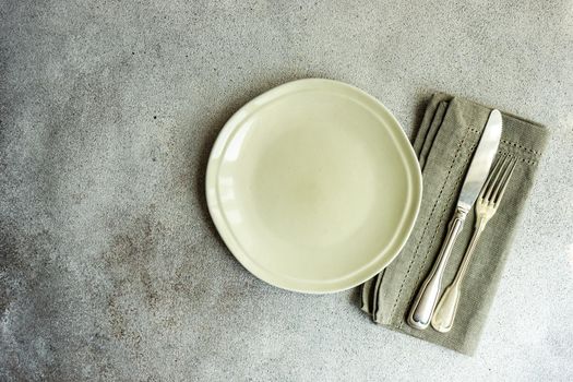 Overhead table setting in minimalistic style on concrete background