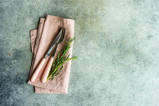 Cutlery set with textile napkin and silverware on concrete table