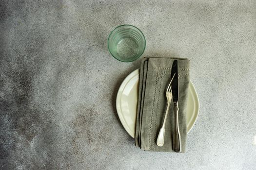 Overhead table setting in minimalistic style on concrete background