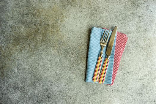 Cutlery set with textile napkin and silverware on concrete table