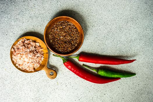 Flax seeds and pink salt in the bowls with fresh spicy chilli pepper on the table