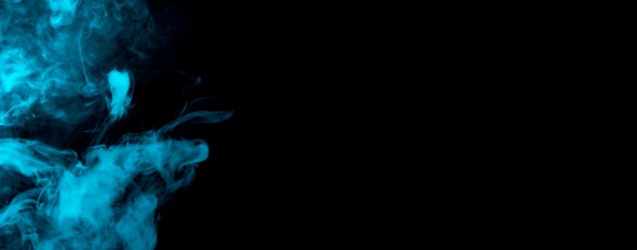 movement of a cloud of blue cigarette vapour, on dark background. banner with illuminated coloured smoke. panoramic.