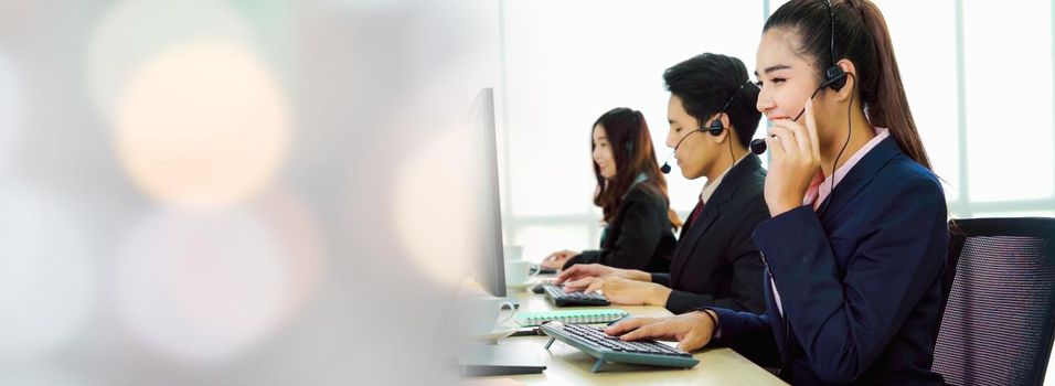 Business people wearing headset working in office in widen view to support remote customer or colleague. Call center, telemarketing, customer support agent provide service on telephone video call.