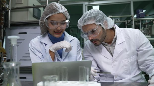 Two scientist in professional uniform working in laboratory for chemical and biomedical experiment