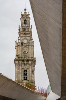 View of the beautiful baroque Church of Clerigos (Igreja dos Clerigos, in Portuguese) and iconic Clerigos Tower, one of the landmarks and symbols of Oporto city in Portugal. Sunset color in blue sky.