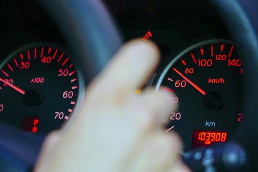 Car dashboard and drivers hand close up