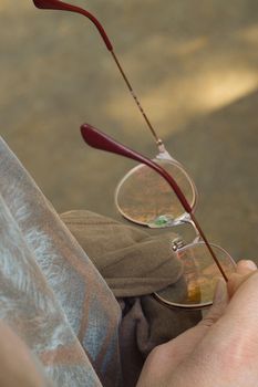 Woman cleaning glasses with tshirt using as a cleaning cloth close up view