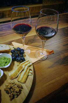 Red wine and appetizers on wooden background
