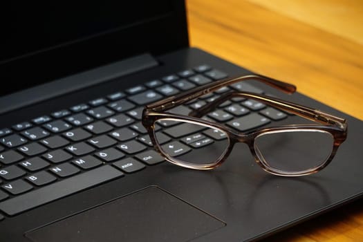 Glasses and computer keyboard close up view business concept on wooden background
