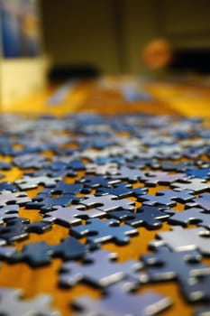 Making puzzle at home on wooden background bokeh effect close up view