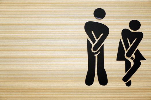 Comic toilet sign symbols with woman and men on wooden background