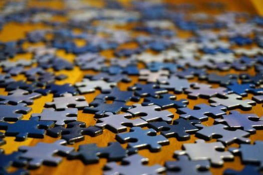 Making puzzle at home on wooden background bokeh effect close up view