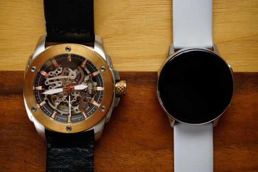 Analog and smart watches on wooden background with copyspace